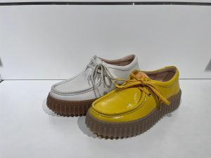 weiße und gelbe Schuhe von Clarks Shoes